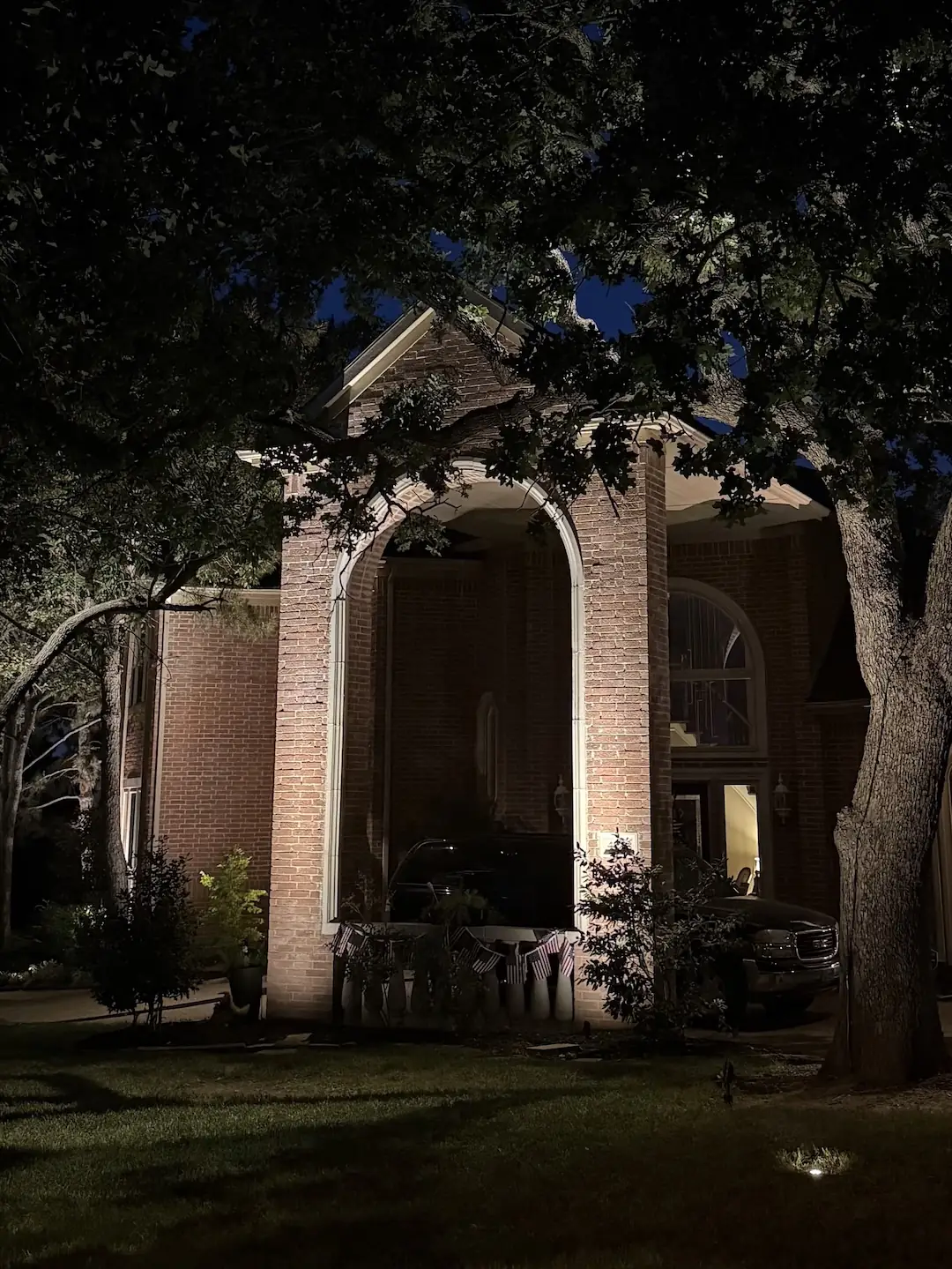 Warm uplighting on brick columns and outdoor living area at night