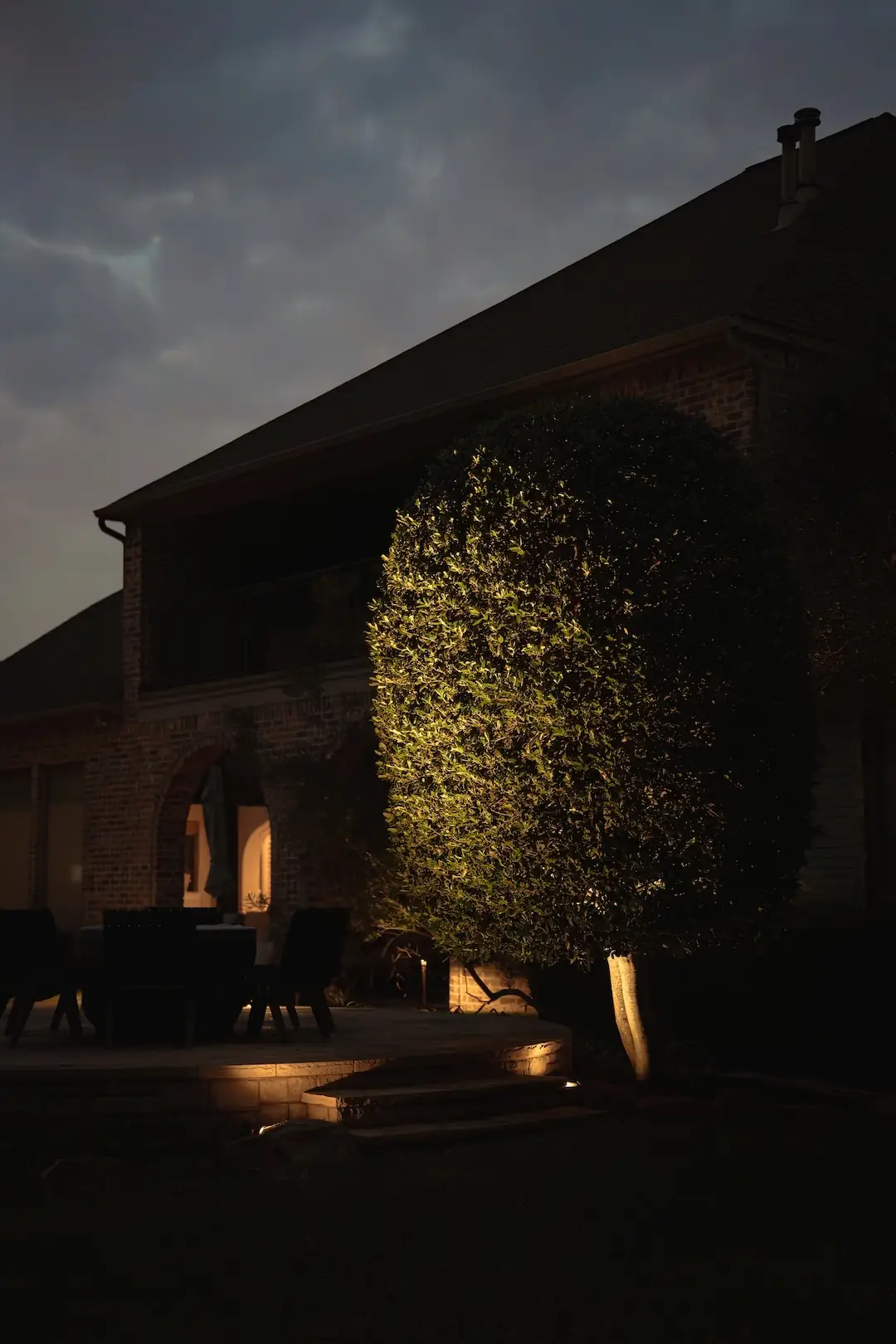 Brick home elevation in North Texas after lighting installation