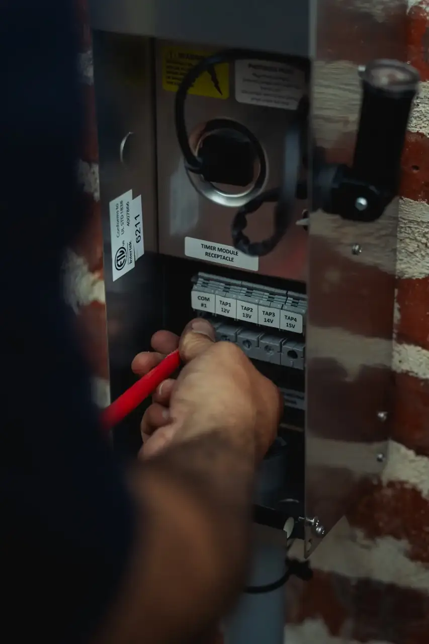 K Legacy Lighting technician servicing a low-voltage lighting transformer